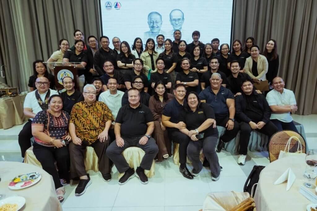 Large group of people posing for a photo in front of a projection screen.